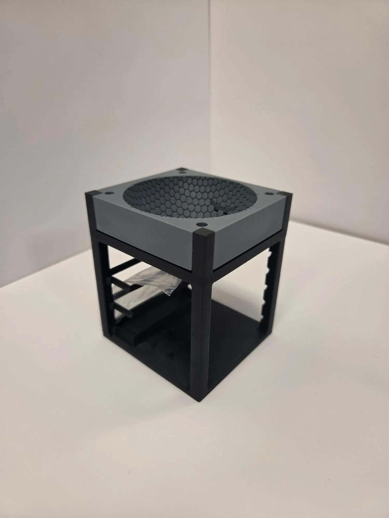 The grey hex dome mounted on the open dark grey shelf frame with three shelf slots visible